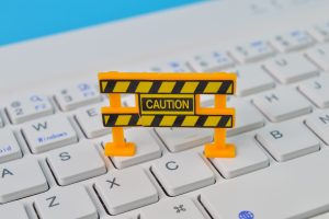 Laptop computer and caution sign. Maintenance, repair, under construction and safety concept.
